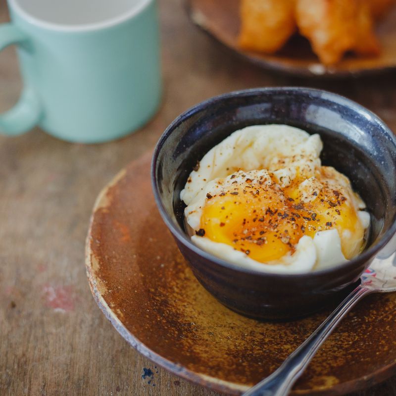 soft boiled eggs in a cup with seasoning